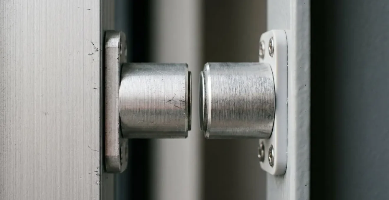 Gros plan sur le mécanisme d'un détecteur d'ouverture magnétique professionnel installé sur une porte
